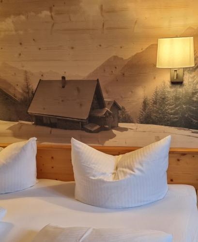 a bedroom with a bed with a picture of a house at Hotel Goldene Rose in Reutte