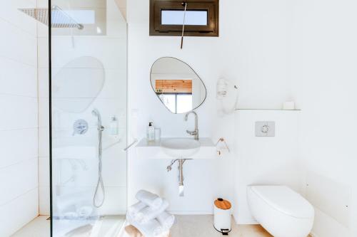une salle de bain blanche avec une douche et un lavabo dans l'établissement Madeira Sunset Cottage - Nature Retreat, à Ponta do Pargo