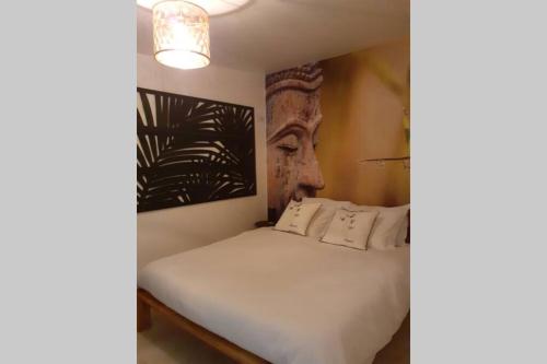 ein Schlafzimmer mit einem Bett mit einem Kopf an der Wand in der Unterkunft LOVE ROOM OUT OF TIME *JACUZZI* in Itteville