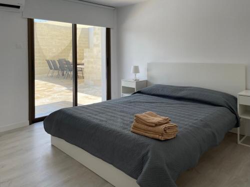 een slaapkamer met een bed met twee handdoeken erop bij Villa Athasia in Yiolou