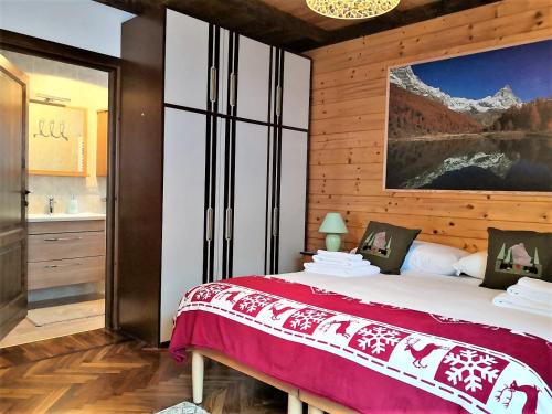 a bedroom with a large bed and a bathroom at Maison Mont Rose in Valtournenche