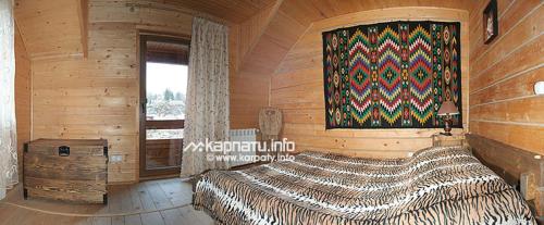 1 dormitorio con 1 cama grande en una habitación de madera en У Тарнавских en Mykulychyn