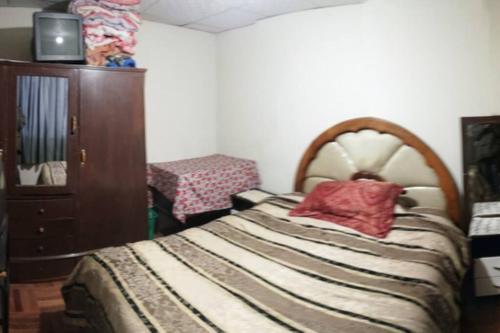a bedroom with a bed and a dresser at Calor De Hogar Con Altura in Potosí