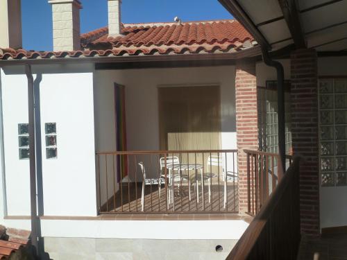 einen Balkon eines Hauses mit einem Tisch und Stühlen in der Unterkunft Alojamiento VuT Rupurupay A in Aldeadávila de la Ribera