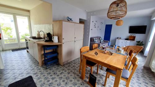 a kitchen with a wooden table and a dining room at Ô de Caps - à 50m de la plage in Sangatte