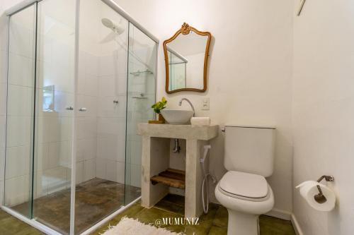 a bathroom with a toilet and a glass shower at Morada do Sol Guest House in Búzios