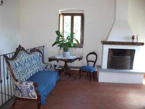 a living room with a chair and a fireplace at Agriturismo La Villa in Bolano