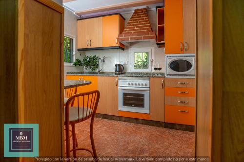 a kitchen with orange cabinets and a table at Casa Ignacita VV in Las Palmas de Gran Canaria