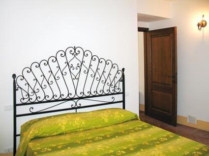 a bedroom with a black bed with a green blanket at Agriturismo La Villa in Bolano