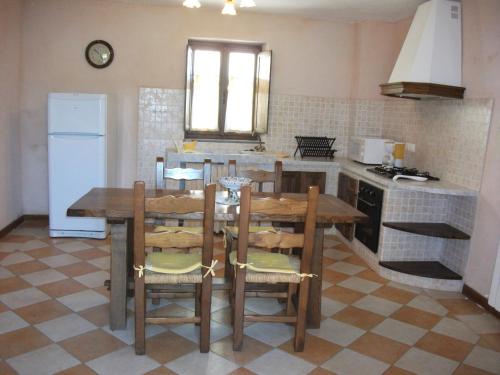 a kitchen with a table and chairs and a refrigerator at Agriturismo La Villa in Bolano