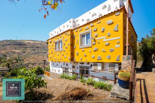 a yellow and white building with a hill in the background at Casa Ignacita VV in Las Palmas de Gran Canaria