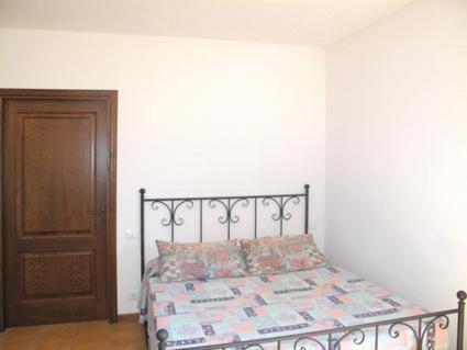 a bedroom with a bed and a wooden door at Agriturismo La Villa in Bolano