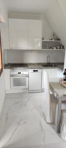 a white kitchen with white appliances and a marble floor at Finca La Punta in Icod de los Vinos