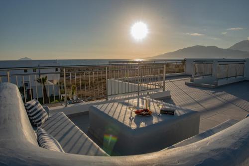 balkon ze stołem i widokiem na ocean w obiekcie Villa Pnoe Seaside w mieście Kalamaki