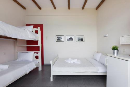 a bedroom with two bunk beds and a kitchen at Pansion Martha in Agios Ioannis Pelio