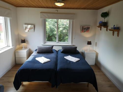 two beds in a room with two windows at Wannborga Destilleri in Borgholm