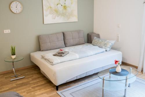 a white couch in a living room with two tables at Ferienwohnung Esther in Singen