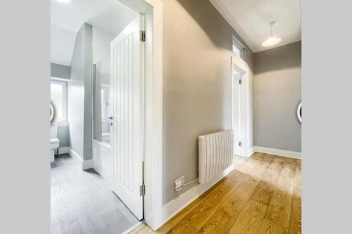 an empty hallway with a white door and wooden floors at No7 Oban Harbour in Oban