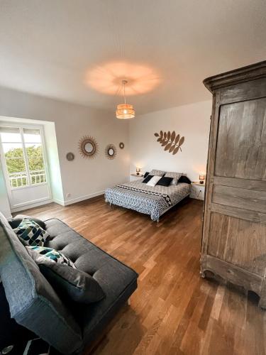 un salon avec un lit et un canapé dans l'établissement LA BUTTE - Maison de vacances Avranches avec vue sur le Mont Saint Michel, à Le Val-Saint-Père