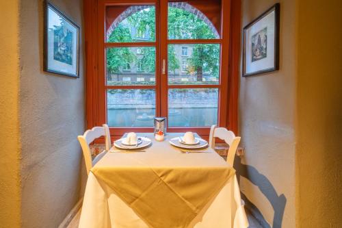 a table with a yellow table cloth and a window at Hotel Ter Brughe by CW Hotel Collection in Bruges