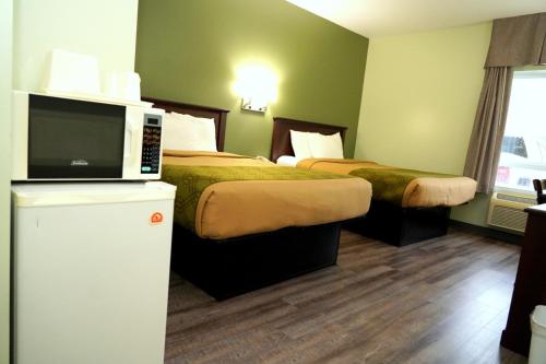 a hotel room with two beds and a tv at Econolodge Huntsville in Huntsville