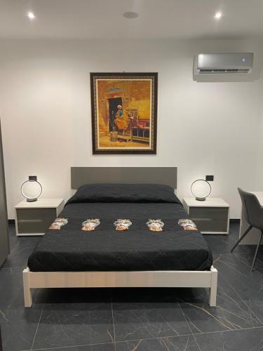 een slaapkamer met een bed met 2 lampen en een schilderij bij Case vacanze donna Ina in Palermo