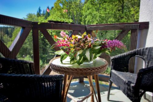 a table with a vase of flowers on a patio at Hotel Las Piechowice in Szklarska Poręba