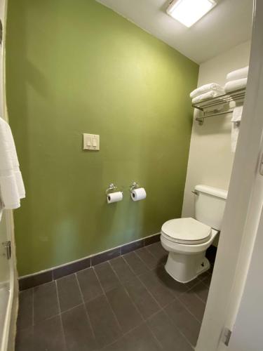 a bathroom with a toilet and green walls at Sleep Inn Atlanta Airport in Atlanta