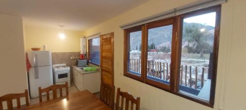 een keuken met een koelkast en een raam met een balkon bij Lo del Chango in Purmamarca