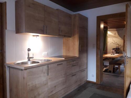 uma cozinha com armários de madeira e um lavatório em Petter 1 em Tobadill