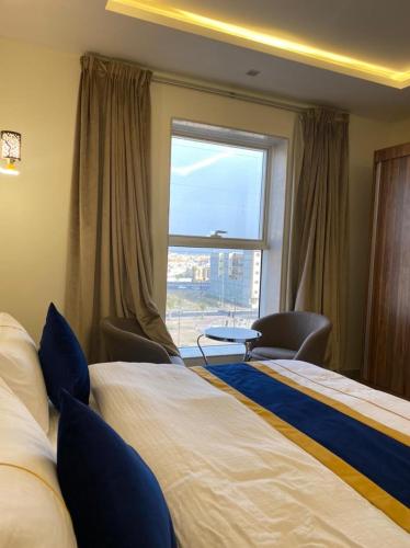een hotelkamer met 2 bedden en een raam bij Golden Inn in Khamis Mushayt