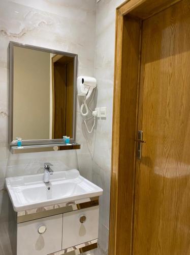 een badkamer met een wastafel en een spiegel bij Golden Inn in Khamis Mushayt