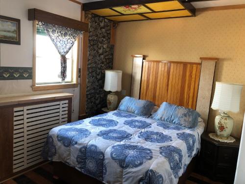a bedroom with a blue and white bed and a window at Heritage Place Hotel in Gravelbourg