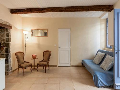 Apartment near the river in Bize Minervois في Bize-Minervois: غرفة معيشة مع سرير وكراسي وطاولة