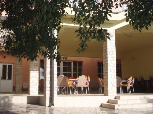 a group of chairs sitting on the porch of a building at Hotel ''Marinko Kozina'' - Medjugorje in Međugorje