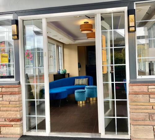 a living room with a blue couch and glass doors at Blu Pacific Hotel in Monterey