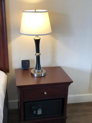 a lamp on a table with a alarm clock on it at Blu Pacific Hotel in Monterey