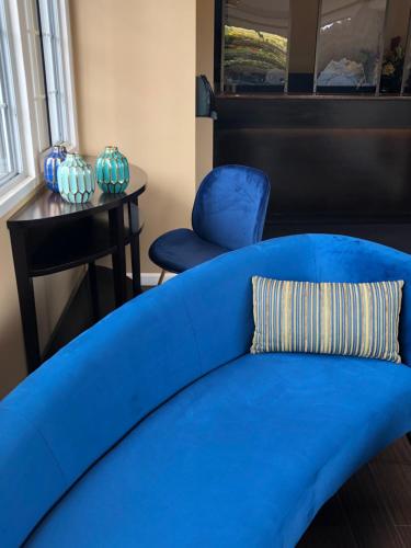 a blue couch and two blue chairs in a room at Blu Pacific Hotel in Monterey