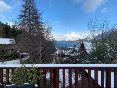 a snowy balcony with a view of the snow covered mountains at Alpine Hideaway - 2 bedroom in Closeburn