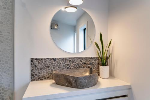 a bathroom with a stone sink and a mirror at Alpine Hide Away - 2 bedroom in Closeburn