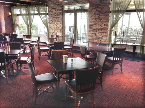 a dining room with tables and chairs and windows at Hotel King in Izumi