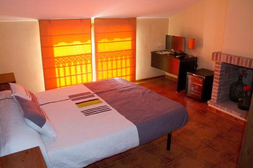 a bedroom with a large bed and a fireplace at Casa Rural Magnanimvs in Vilafames