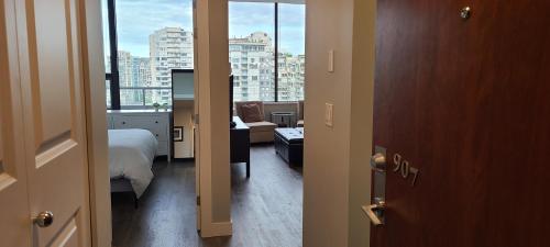 a room with a bed and a view of a city at Howe Street Apartment with Views in Vancouver