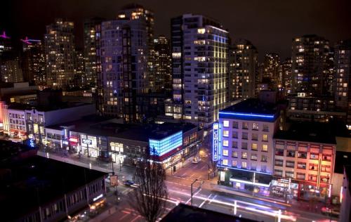 a view of a city at night with lights at Howe Street Apartment with Views in Vancouver