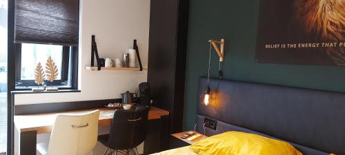 een slaapkamer met een bureau, een bed en een raam bij B&B de Droomgaard in Kerkdriel