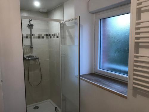 La salle de bains est pourvue d'une douche et d'une fenêtre. dans l'établissement Hébergements situés à 6 kms du Mont Saint Michel, à Tanis