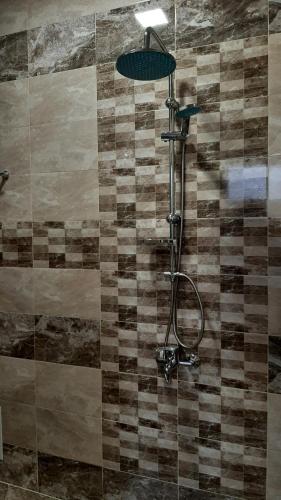 a shower with a shower head in a bathroom at Арт in Sliven