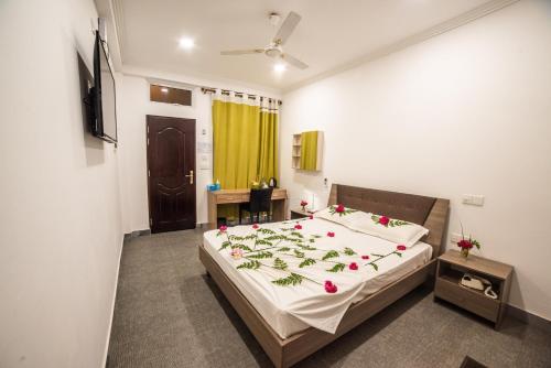 a bedroom with a bed with flowers on it at Dhangethi INN in Dhangethi