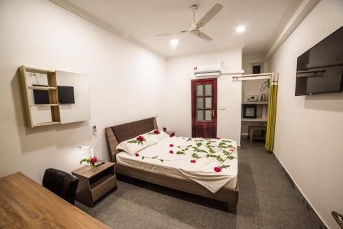 a bedroom with a bed with flowers on it at Dhangethi INN in Dhangethi