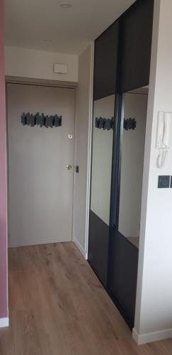 une pièce vide avec une porte et un miroir dans l'établissement Le yacht club1, à Blonville-sur-Mer